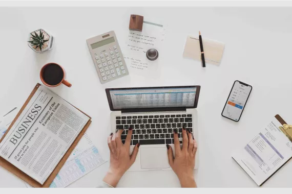woman's hands typing on laptop