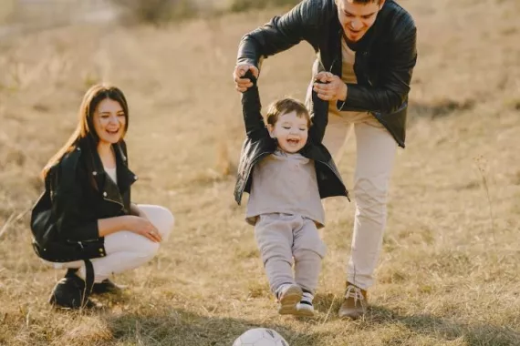 Eine junge Familie spielt Fussball auf einer Wiese